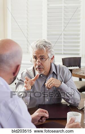 Stock Photography - Businessmen talking in cafe. Fotosearch