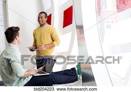 Businessmen talking in office View Large Photo Image Stock Image - Businessmen talking in office. Fotosearch