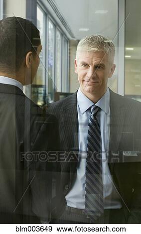 Stock Photo - Businessmen talking in office. Fotosearch
