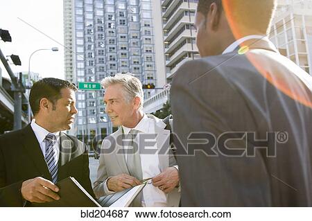 Businessmen talking on city street View Large Photo Image Stock Photo - Businessmen talking on city street. Fotosearch