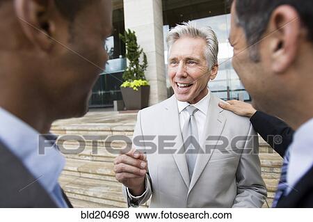 Stock Photo - Businessmen talking on city street. Fotosearch