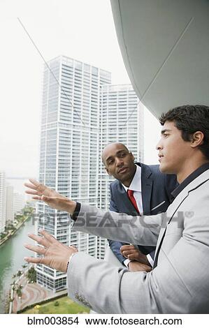 Picture - Businessmen talking on urban balcony. Fotosearch