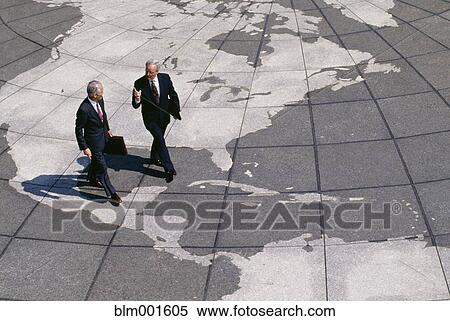 Stock Photography - Businessmen walking on map of globe. Fotosearch