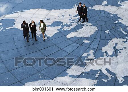 Stock Image - Businesspeople walking on map of globe. Fotosearch