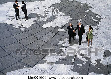 Stock Photo - Businesspeople walking on map of globe. Fotosearch