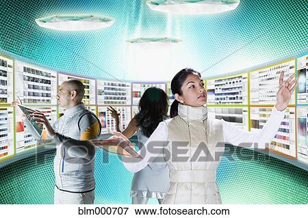Businesspeople working at futuristic control panels View Large Photo Image Stock Photo - Businesspeople working at futuristic control panels. Fotosearch