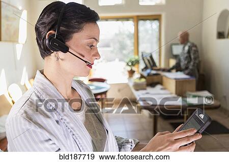 Stock Photo - Businesswoman using digital tablet and headset in office. Fotosearch