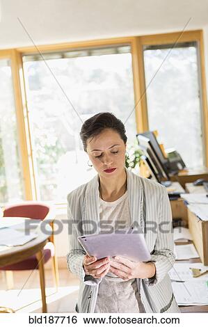 Stock Photograph - Businesswoman using digital tablet in office. Fotosearch