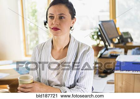 Businesswoman wearing headset in office View Large Photo Image Stock Image - Businesswoman wearing headset in office. Fotosearch