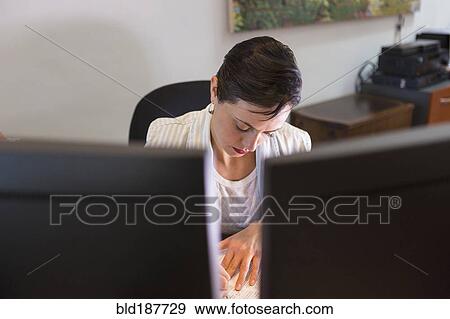 Businesswoman working on computer in office View Large Photo Image Stock Photo - Businesswoman working on computer in office. Fotosearch