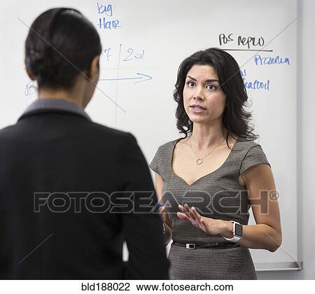 Businesswomen talking in office View Large Photo Image Stock Image - Businesswomen talking in office. Fotosearch
