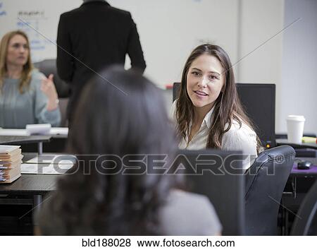 Stock Photo - Businesswomen talking in office. Fotosearch