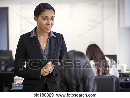 Businesswomen talking in office View Large Photo Image Stock Photo - Businesswomen talking in office. Fotosearch