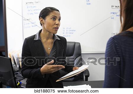 Stock Photography - Businesswomen talking in office. Fotosearch