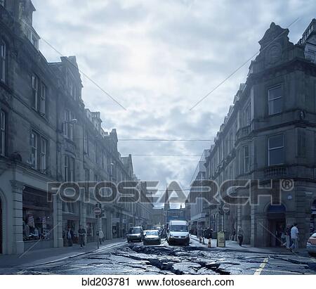 Stock Image - Cars driving on cracked urban pavement. Fotosearch