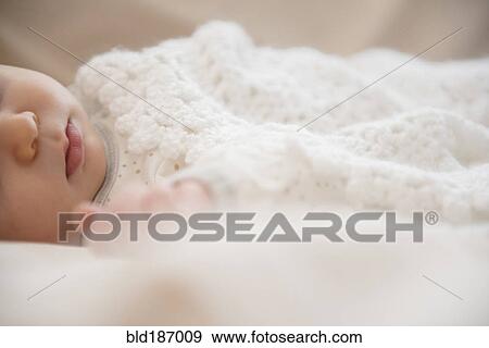 Stock Photo - Caucasian baby wrapped in blanket. Fotosearch