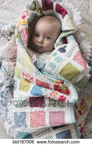 Stock Photograph - Caucasian baby wrapped in blanket. Fotosearch