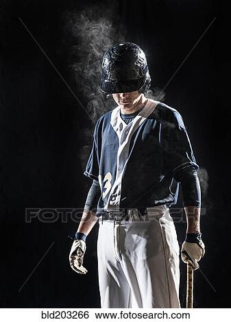 Stock Photograph - Caucasian baseball player standing under lights. Fotosearch