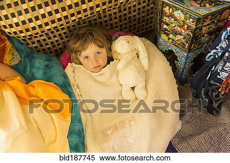 Stock Photography - Caucasian boy laying in blanket pile. Fotosearch