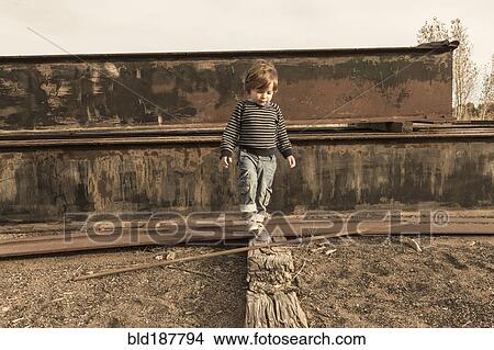 Picture - Caucasian boy walking on wall. Fotosearch