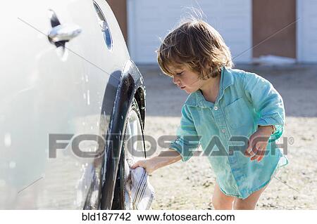Stock Image - Caucasian boy washing car. Fotosearch