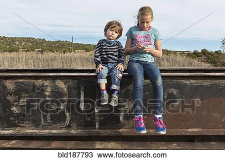 Caucasian brother and sister sitting outdoors View Large Photo Image Stock Image - Caucasian brother and sister sitting outdoors. Fotosearch