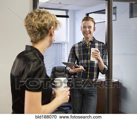 Stock Image - Caucasian business people talking in office. Fotosearch