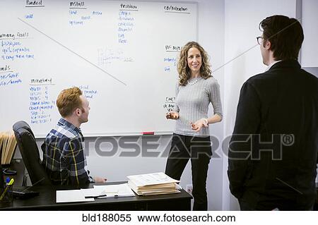 Stock Photography - Caucasian business people talking in office. Fotosearch