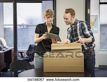 Stock Photo - Caucasian business people using digital tablet in office. Fotosearch