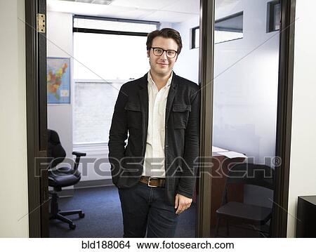 Caucasian businessman smiling in office doorway View Large Photo Image Picture - Caucasian businessman smiling in office doorway. Fotosearch