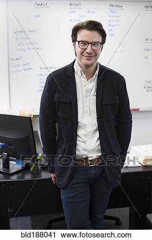 Stock Image - Caucasian businessman smiling in office. Fotosearch