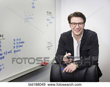 Caucasian businessman using cell phone in office View Large Photo Image Stock Photo - Caucasian businessman using cell phone in office. Fotosearch