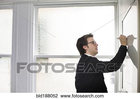 Stock Image - Caucasian businessman writing on whiteboard in office. Fotosearch