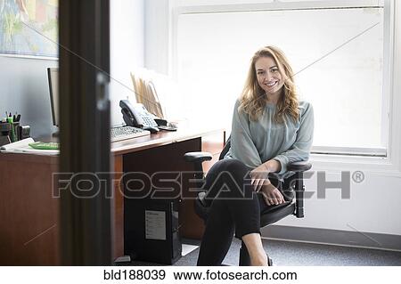 Stock Photo - Caucasian businesswoman smiling in office. Fotosearch