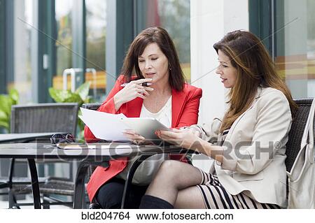 Picture - Caucasian businesswomen working at cafe. Fotosearch