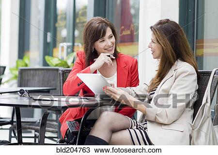Stock Image - Caucasian businesswomen working at cafe. Fotosearch