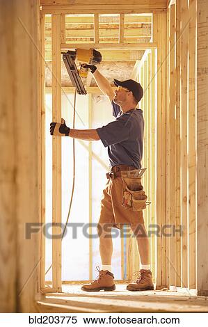 Stock Photography - Caucasian carpenter working on building. Fotosearch