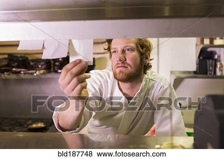Caucasian chef reading orders in restaurant kitchen View Large Photo Image Stock Photo - Caucasian chef reading orders in restaurant kitchen. Fotosearch