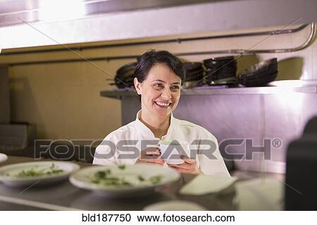 Stock Image - Caucasian chef smiling in restaurant kitchen. Fotosearch