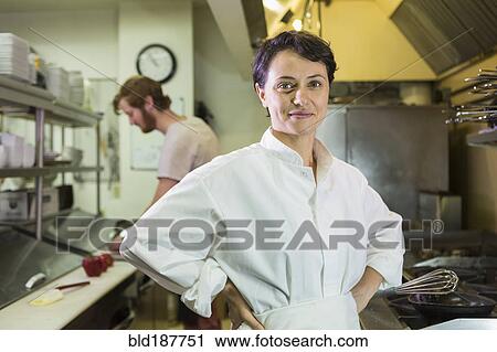 Stock Image - Caucasian chef smiling in restaurant kitchen. Fotosearch