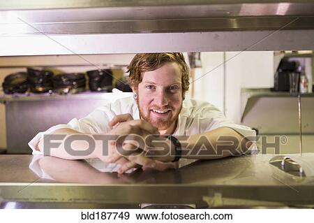 Stock Photo - Caucasian chef smiling in restaurant kitchen. Fotosearch