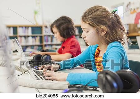 Caucasian children using laptops in library View Large Photo Image Stock Photography - Caucasian children using laptops in library. Fotosearch