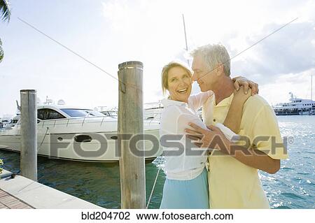 Caucasian couple hugging on dock View Large Photo Image Stock Image - Caucasian couple hugging on dock. Fotosearch