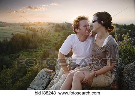 Stock Photo - Caucasian couple hugging on remote hilltop. Fotosearch
