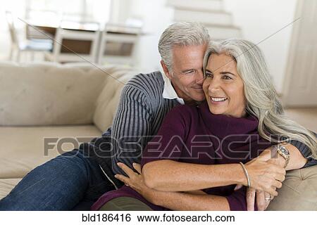 Caucasian couple hugging on sofa View Large Photo Image Stock Photograph - Caucasian couple hugging on sofa. Fotosearch