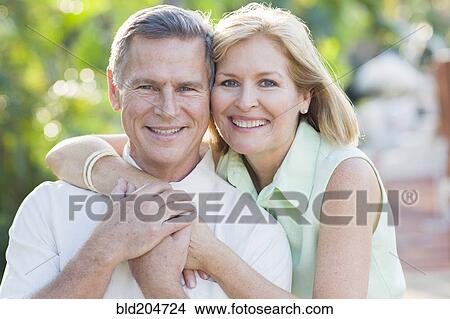 Picture - Caucasian couple hugging outdoors. Fotosearch