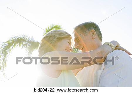 Stock Image - Caucasian couple hugging outdoors. Fotosearch