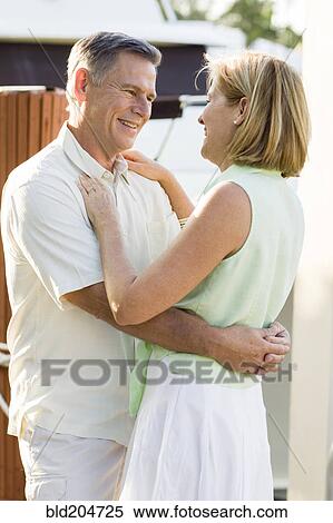 Stock Photography - Caucasian couple hugging outdoors. Fotosearch