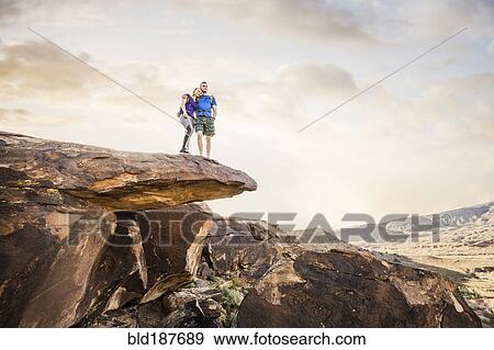 Caucasian couple on rock formation admiring landscape View Large Photo Image Stock Photo - Caucasian couple on rock formation admiring landscape. Fotosearch