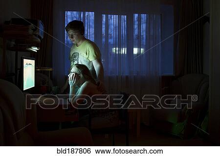Stock Photograph - Caucasian couple using computer at night. Fotosearch